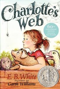 Cover art for Charlotte's web shows a young girl holding a piglet.