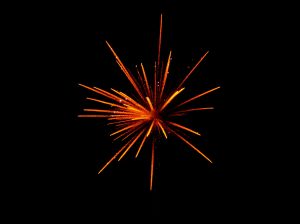Red and orange fireworks explode on a black background
