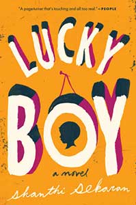 The book cover for Lucky Boy has a golden yellow background. The "O" in "boy" has been made to look like a hanging photo. In the center is the profile of a child.